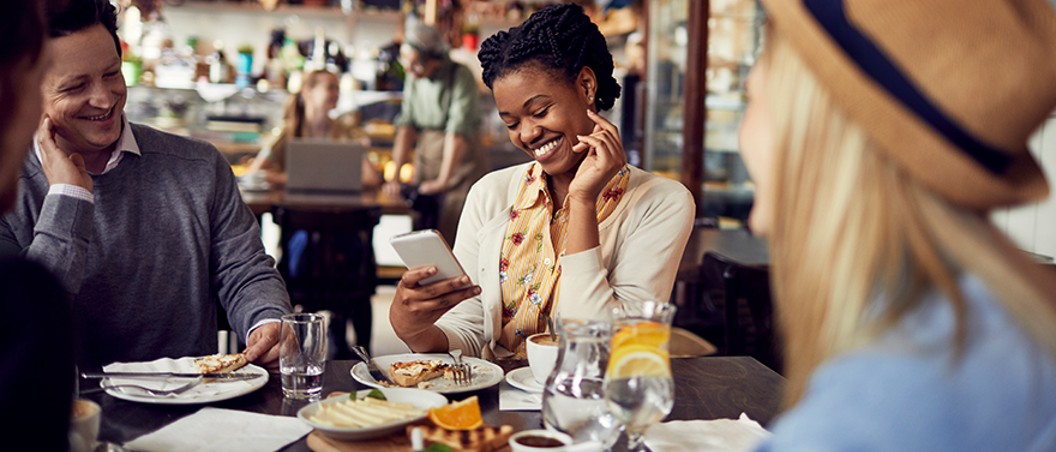 mobile banking near syracuse ny from geddes federal savings and loan association image of women using phone to bank in a restaurant