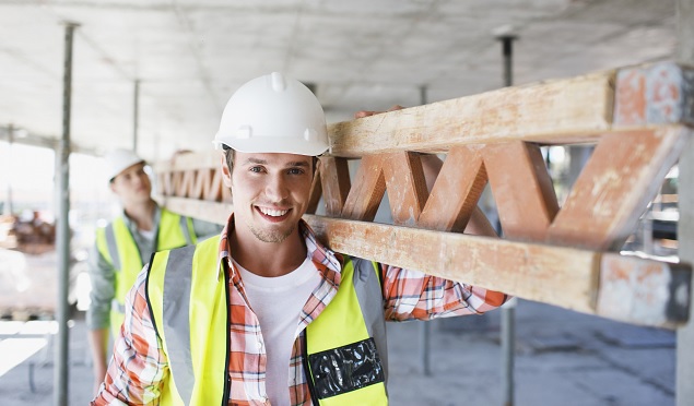 construction loan rates near syracuse ny image of smiling construction worker carrying materials on construction site