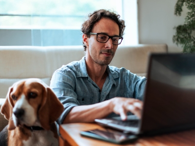 mortgage refinance near syracuse ny man on laptop next to dog
