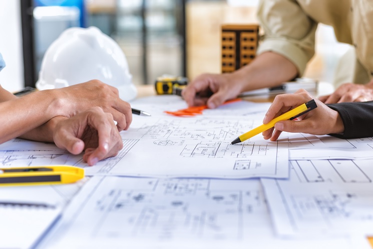 construction loans near syracuse ny image of hands and pencils pointing at blueprints